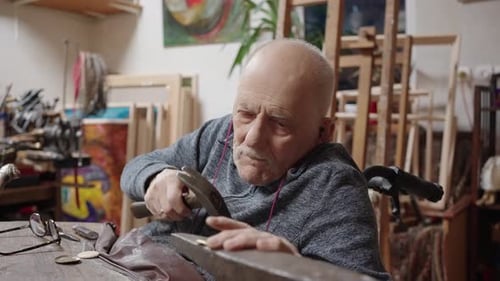 Senior Elderly Master Jeweler in Wheelchair Works in a Workshop