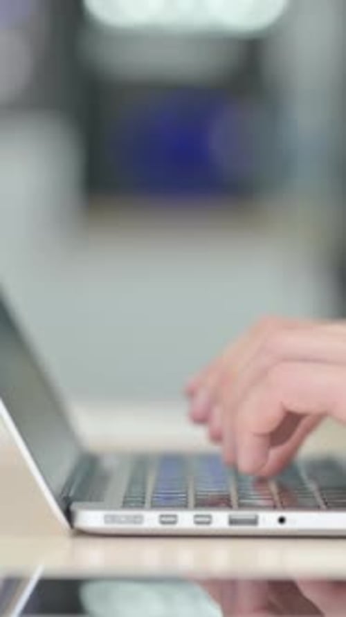 Side View of Male Hands Typing on Laptop, vertical video
