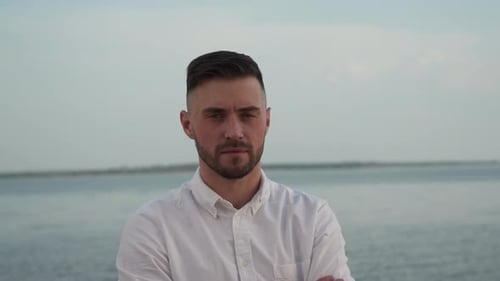 Confident Man Standing by the Calm Ocean