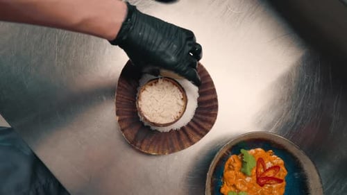 restaurant chef serves freshly cooked rice in a coconut plate adds lime professional Asian cuisine