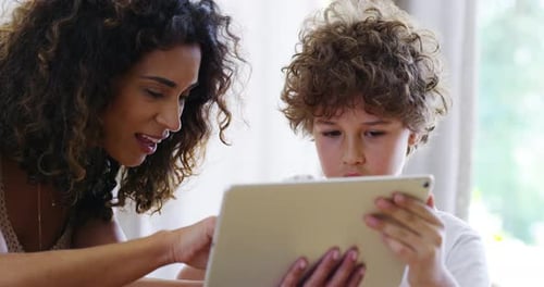 Woman Helping Child with Tablet at Home