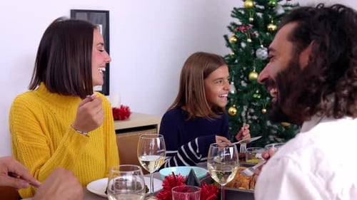 Laughing Family Enjoying a Christmas Meal Together