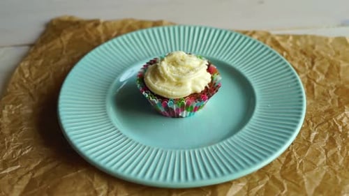 Colorful Cupcake with White Icing on Blue Plate