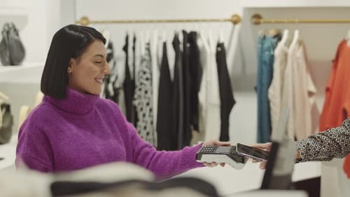 Female Shop Assistant Working at Counter in Boutique