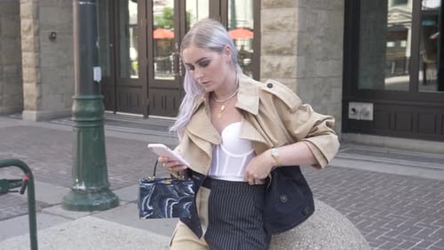 Stylish Woman in Bustier Using Smart Phone on City Sidewalk Adult