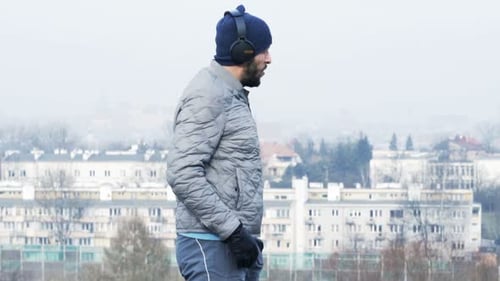 Young Man Jogging and Using Smartphone in City Park Adult