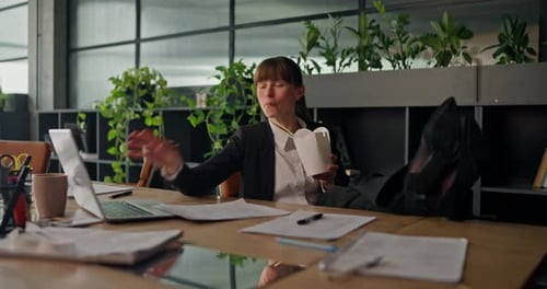 Woman Eating Takeout Lunch at Her Office Desk
