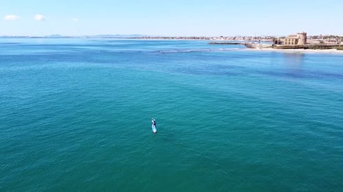 Seascape and sportsman practicing paddle surf in Pilar de la Horadada beach coast view from aerial d