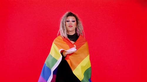 Young Adult Draped in Pride Flag Smiling