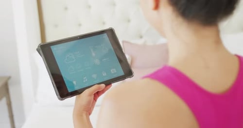 Woman Controlling Smart Home With Tablet Device