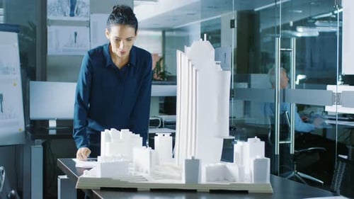 Long Shot of the Female Architectural Designer Adding Component to a Building Model, She Works on a
