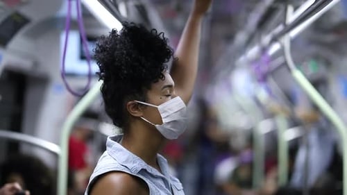 African american woman commuting in subway wearing surgical mask
