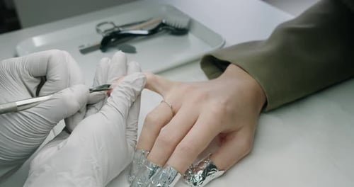Manicurist Removes Gel Polish in a Nail Salon