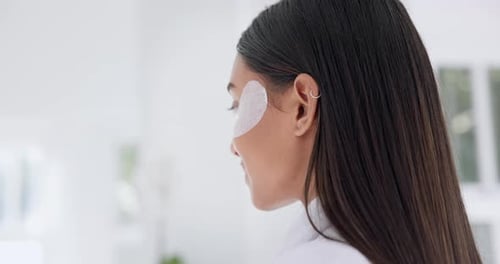 Woman Applies Under Eye Mask in Bathroom