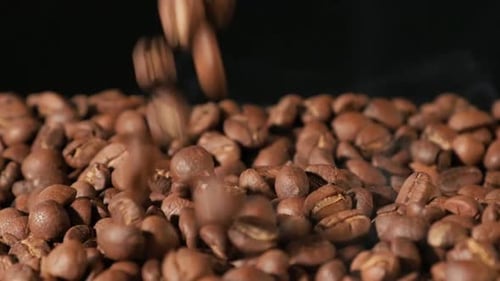 Slow motion of roasted coffee beans falling.