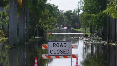 Flooded Street in Florida After Hurricane Rainfall with Road Closed Signs Blocking Driving of Cars