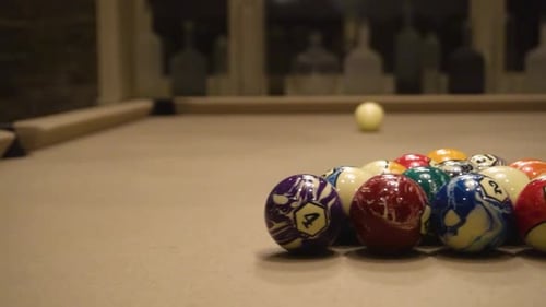 Billiards table with pool ques and balls.