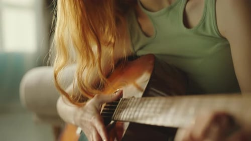 Woman Plays Acoustic Guitar at Home