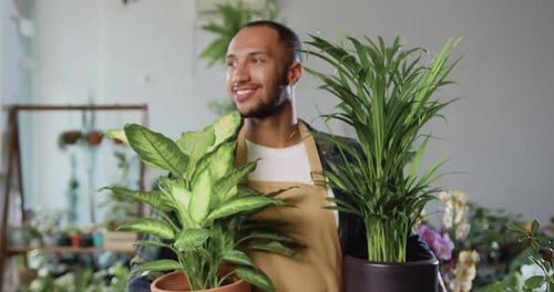 Young Adult Man Holding Plants and Smiling