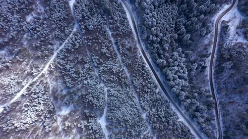 Aerial view of winter road in snow covered mountain forest