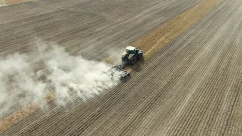 Agricultural Industrial Tractor Plows Soil Field For Sowing In Ukraine, Kyiv City, Aerial Shot
