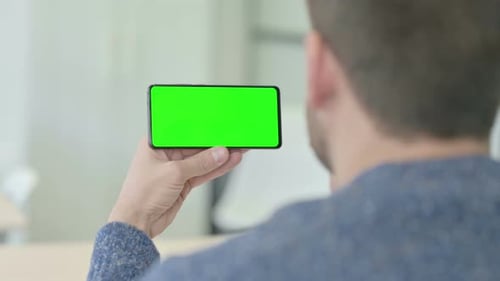 Man Holding Horizontal Smartphone with Green Screen
