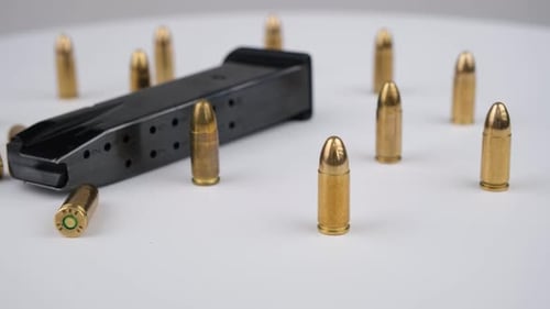 Bullets and Black Magazine Displayed on White Surface
