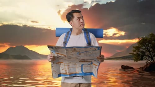 Asian Male Hiker Looking At The Map Then Looking Around At A Lake
