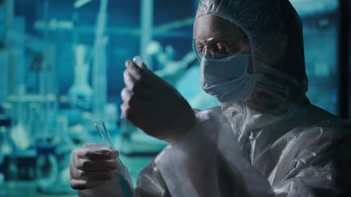 Scientist in Hazmat Suit Works with Liquid Sample