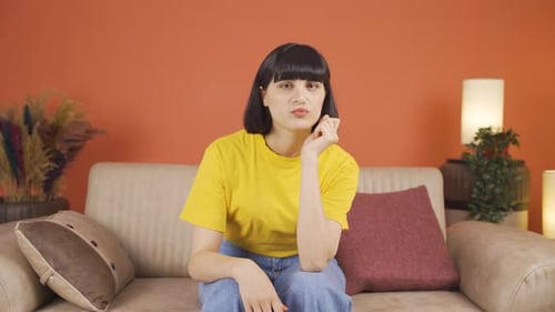 Young Woman Sitting on Couch Looking Sad