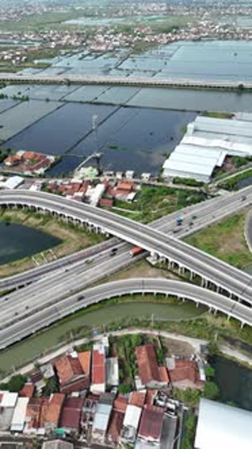 Aerial shot of highway intersection with house and water landscape