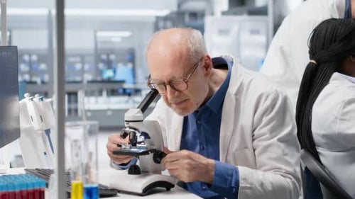 Scientist using microscope in modern bright lab