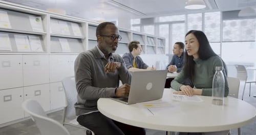 Business People Working on Presentation Together on Laptop in Office