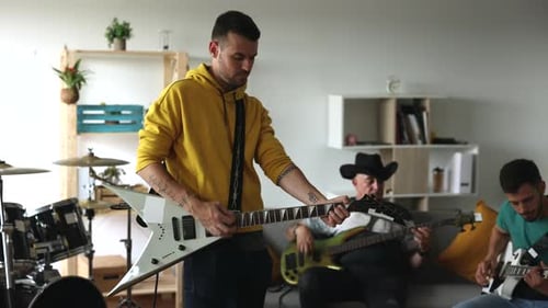 music band rehearsing in the studio, electric guitars, bass, and drums.