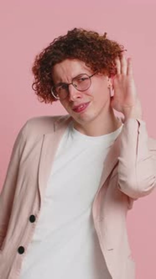 Caucasian Man Trying Hear you Looking Confused and Frowning Keeping Arm Near Ear for Louder Voice
