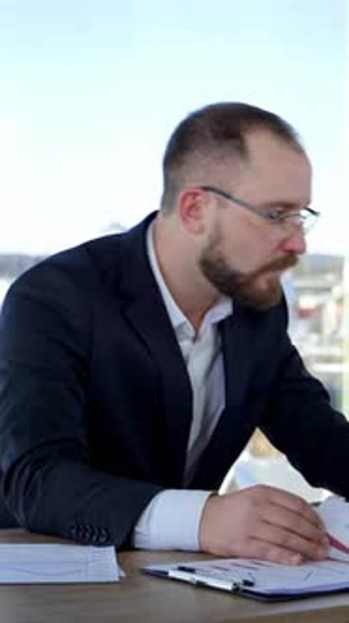 Nervous businessman at office. Office worker sitting at his desk dispirited of some difficulties.