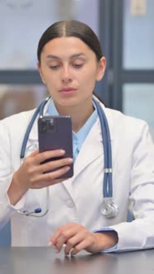 Mixed Race Female Doctor Using Smartphone in Hospital, Vertical Video