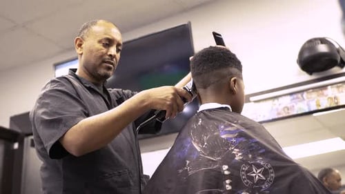 Barber shop precision as young boy receives haircut from skilled barber