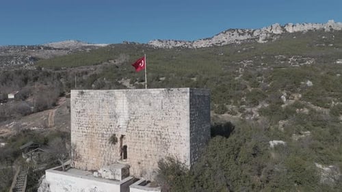 Castle wall and flag in the middle of the mountain, drone view, Belenkeşlik Castle, Turkey