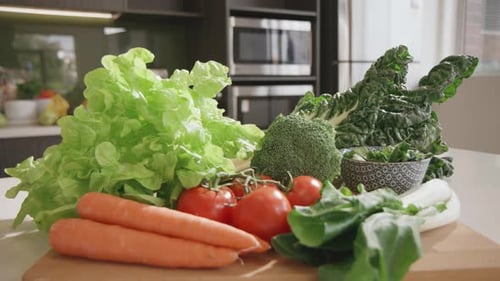Fresh vegetables on wooden cutting board in kitchen