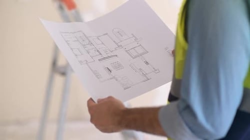 Close Up Hand of Professional Engineer Holding Design Plan Drawing Paper in Hand