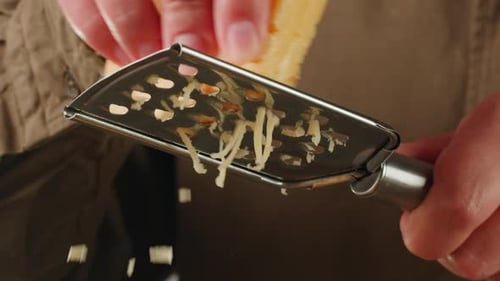 Italienische Käsereibe, Nahaufnahme von geriebenem Käsereibe für Pasta oder Pizza, Parmesan oder Gouda