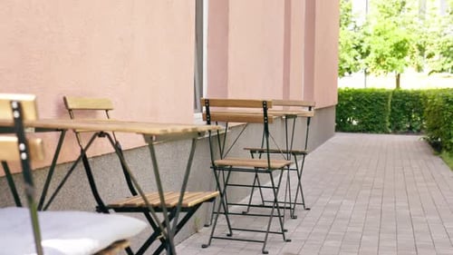 Close Up in a Restaurant on the Street on Plank Table a Blue Plate with a Warm Salad with Avocado
