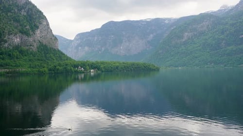 Ein wunderschöner Blick auf den See mit atemberaubender Berglandschaft und historischen Gebäuden.