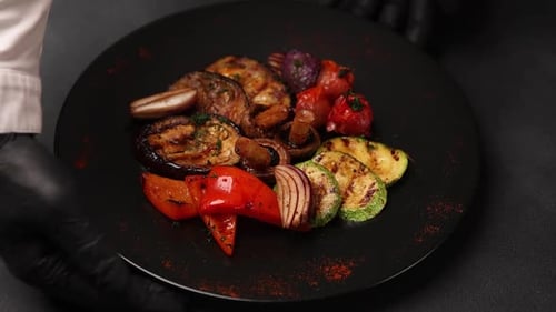 Plate of Grilled Vegetables Turned by Black Gloves