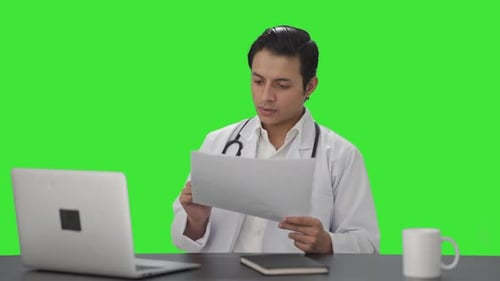 Indian doctor checking medical reports Green screen