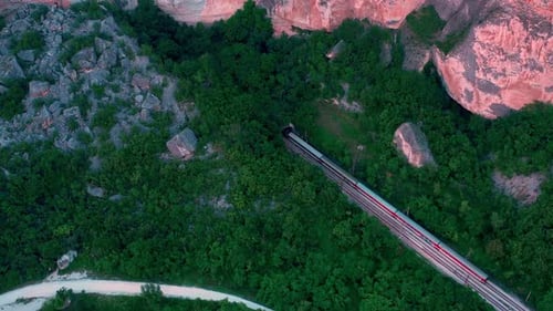 Vista aérea do trem entrando em um túnel através das rochas