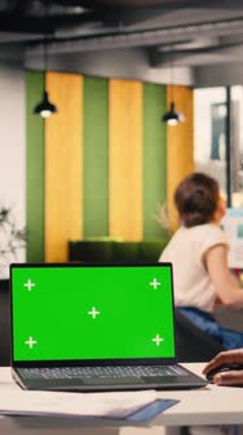 Vertical Video Blue Screen on Tablet and Green Screen on Laptop in Office Workspace