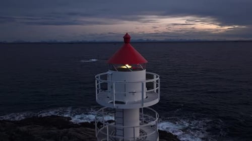 Die Dunkelheit erhellt Ein bezaubernder Leuchtturm mit rotem Dach ziert die Küste der Lofoten