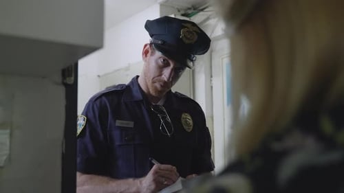 Police officer taking notes listening to woman's testimony or statement or complaint. Cop writing do